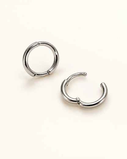 Silver huggie hoops with one closed and one open to show the hinge