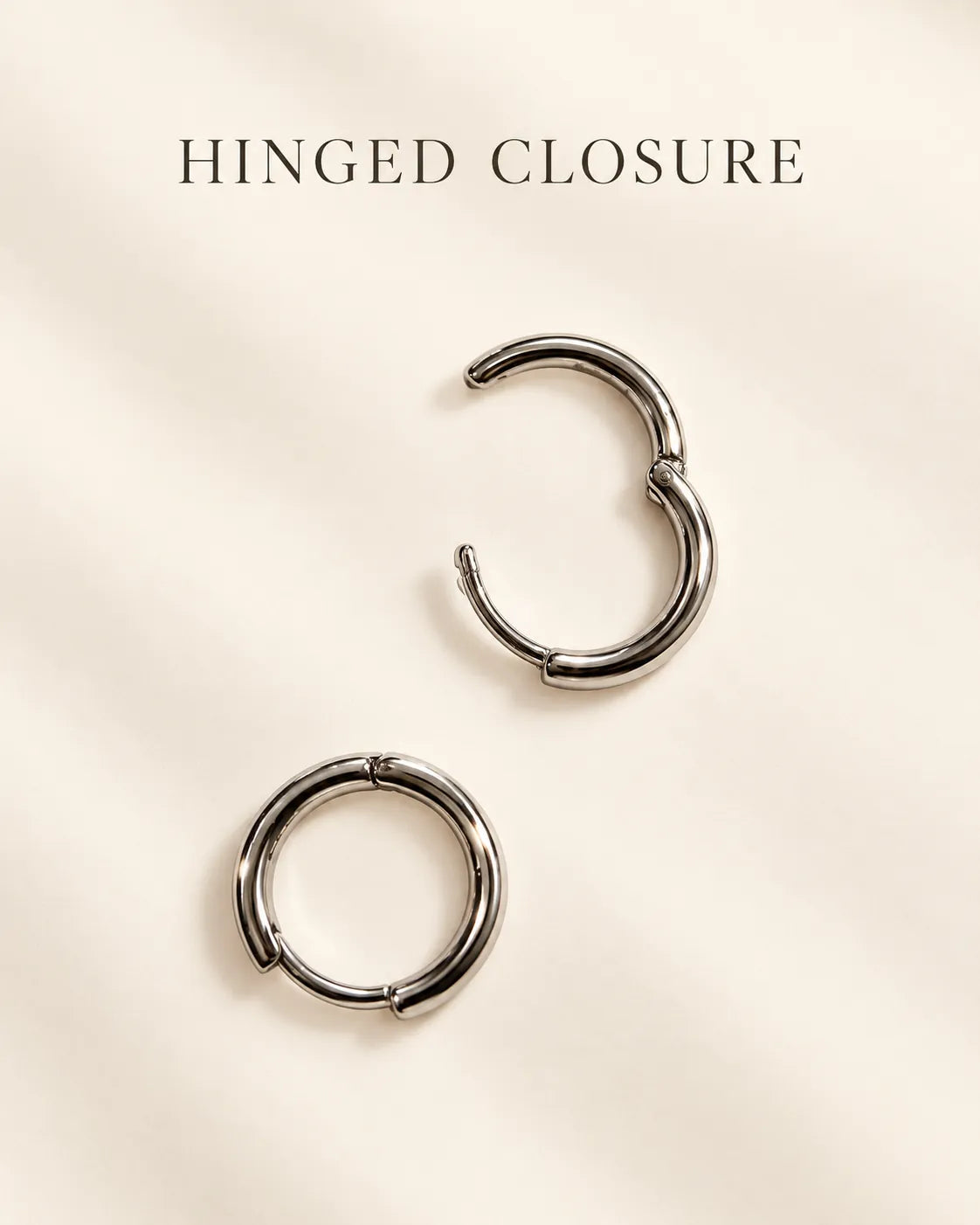 Silver huggie hoops on a cream card with Hinged Closure text