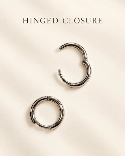 Silver huggie hoops on a cream card with Hinged Closure text