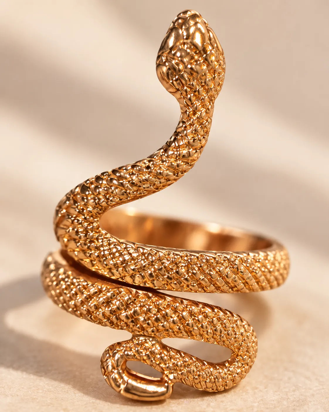Close-up of the gold snake ring's coiled body and sculpted head