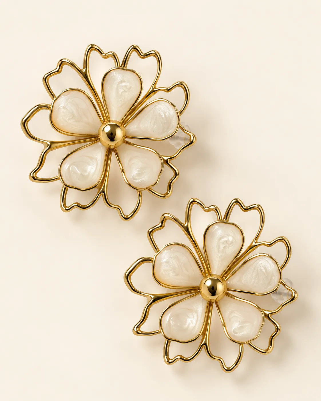 Aurelia white petal flower stud earrings with gold-tone outline on a cream background