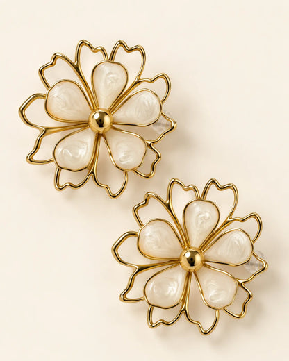 Aurelia white petal flower stud earrings with gold-tone outline on a cream background