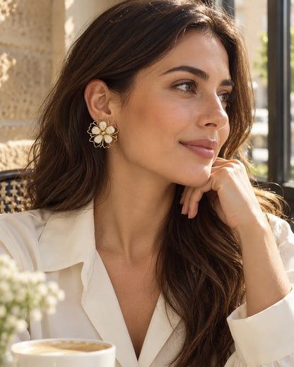 Model in a white shirt at a cafe wearing the Aurelia flower studs