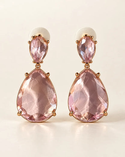 Pink Elara two-stone teardrop earrings on a cream background