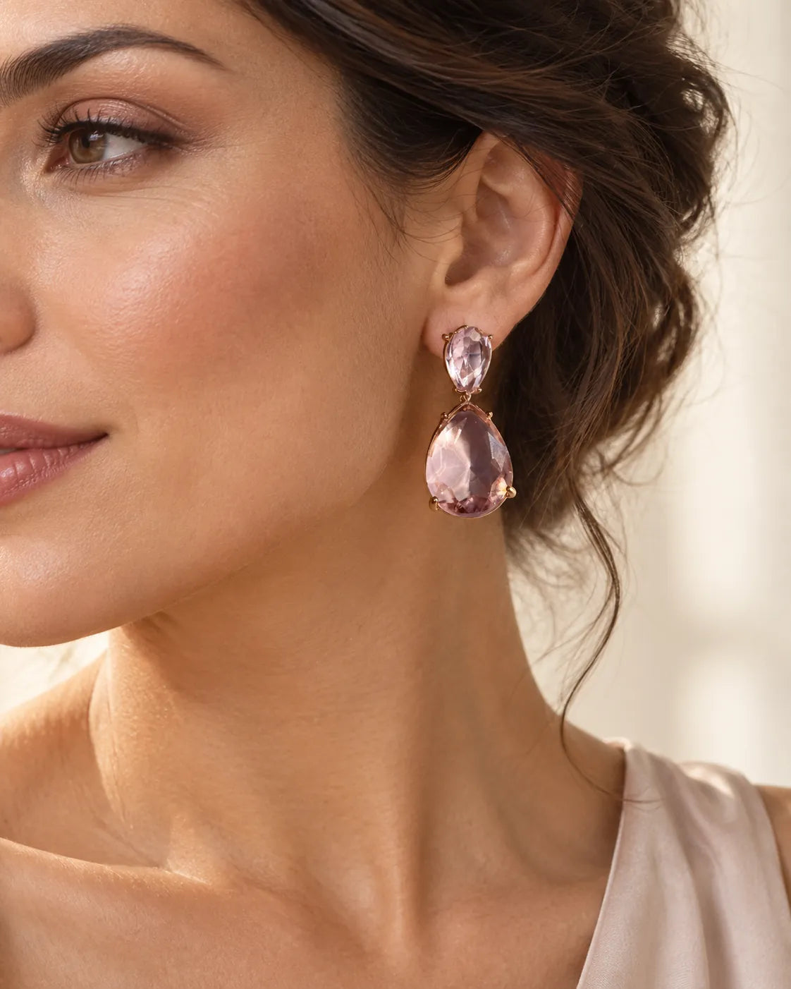 Close-up of a model's ear wearing the pink crystal teardrop earring