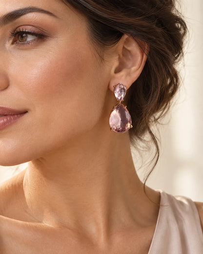 Close-up of a model's ear wearing the pink crystal teardrop earring