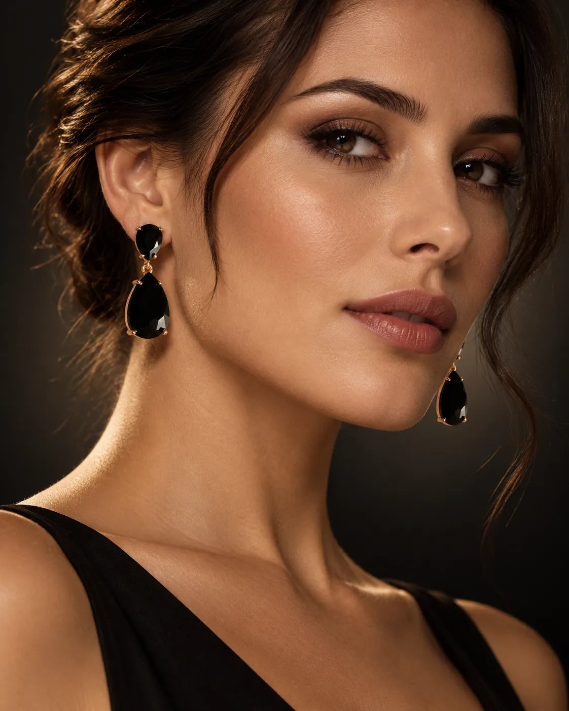 Model in a black top wearing the black crystal drop earrings against a dark backdrop