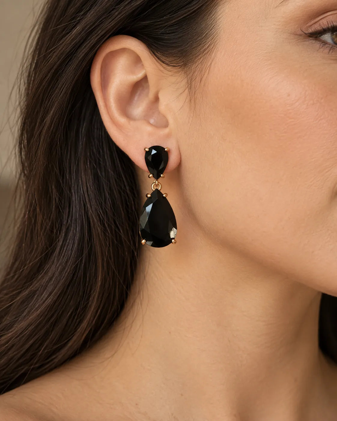 Close-up of a model's ear wearing the black crystal teardrop earring