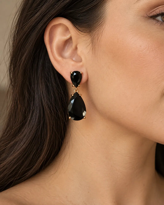 Close-up of a model's ear wearing the black crystal teardrop earring