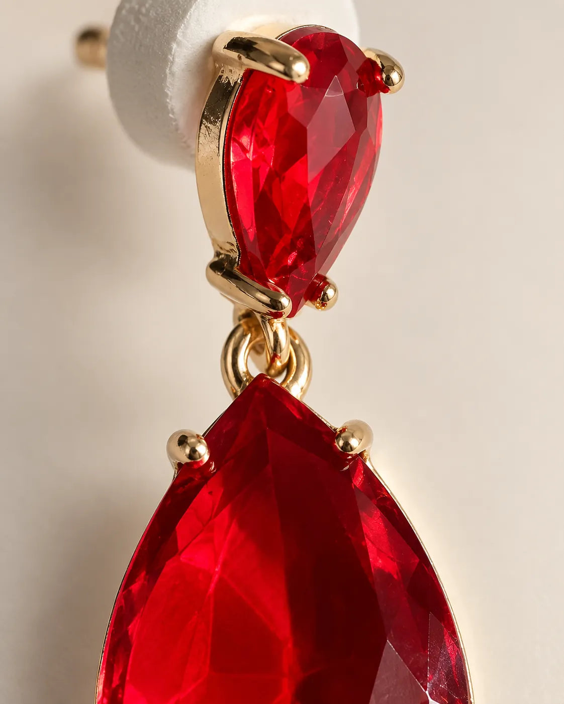 Close-up of the ruby-red faceted crystals and gold-tone claws