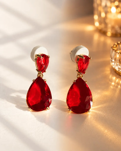Red crystal teardrop earrings in warm glowing light