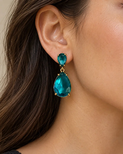 Close-up of a model's ear wearing the blue crystal teardrop earring