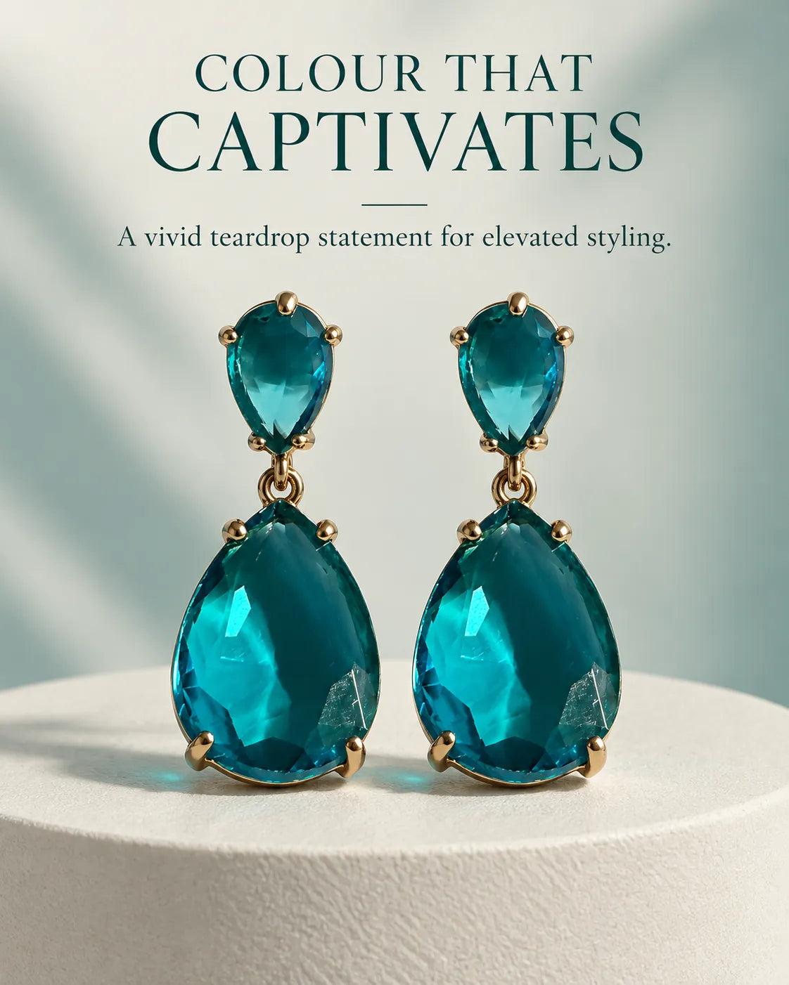Styled graphic of the blue two-stone drop earrings on a white pedestal