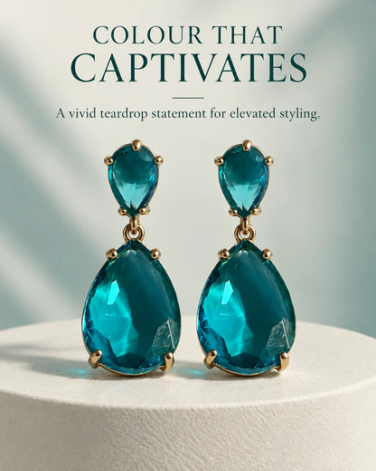 Styled graphic of the blue two-stone drop earrings on a white pedestal