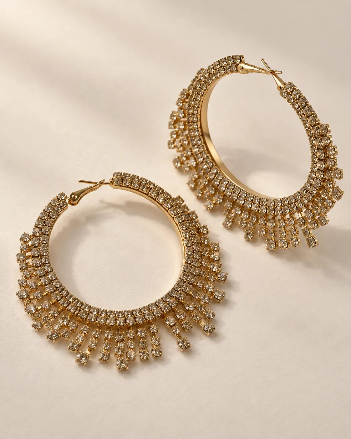 Aurelia gold-tone crystal fringe hoop earrings on a cream background