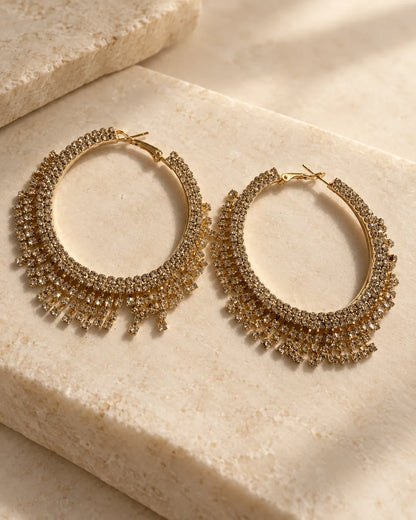Gold crystal fringe hoops resting on a stone block