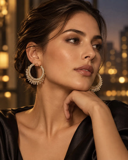 Model in black with a city backdrop at night wearing the gold fringe hoops