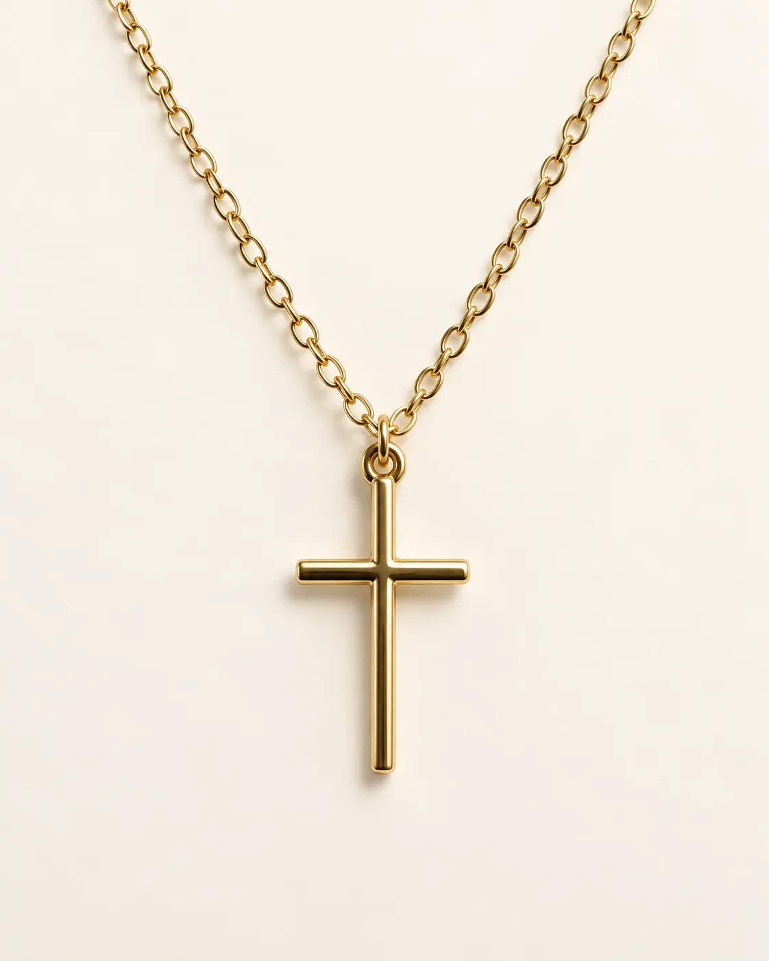Gold-tone Élodie cross pendant necklace on a cream background
