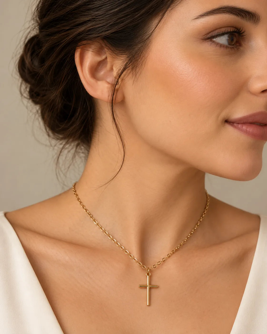 Model in a white top wearing the slim gold cross necklace, side view