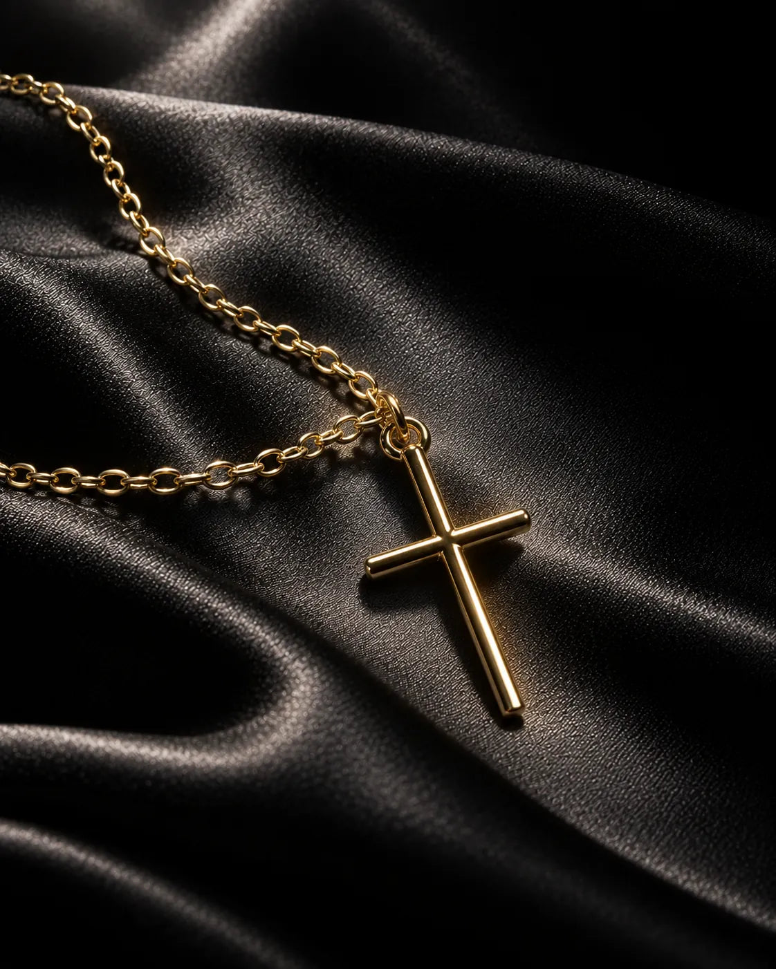 Gold-tone cross necklace on dark black satin