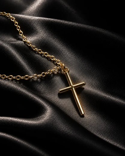 Gold-tone cross necklace on dark black satin