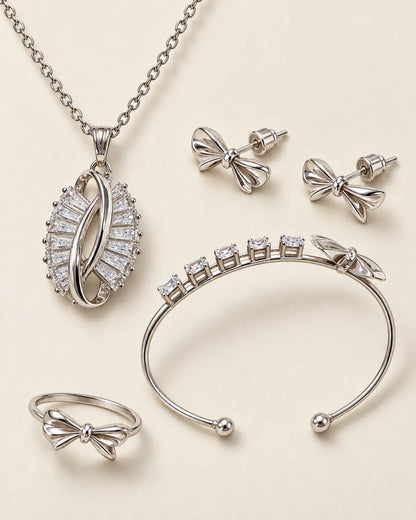 Silver-tone zircon bow set with necklace, studs, cuff and ring on cream