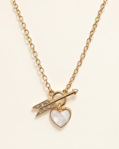 Gold-tone Amélie heart and arrow toggle necklace on a cream background