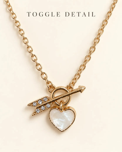 Gold toggle necklace with Toggle Detail text on a cream background