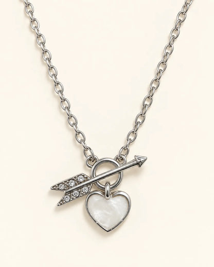 Silver-tone Amélie heart and arrow toggle necklace on a cream background