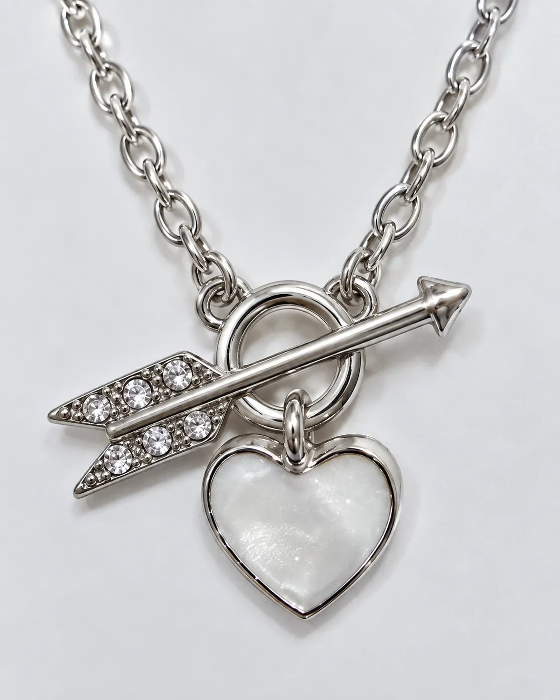 Close-up of the silver crystal arrow, ring and white heart drop