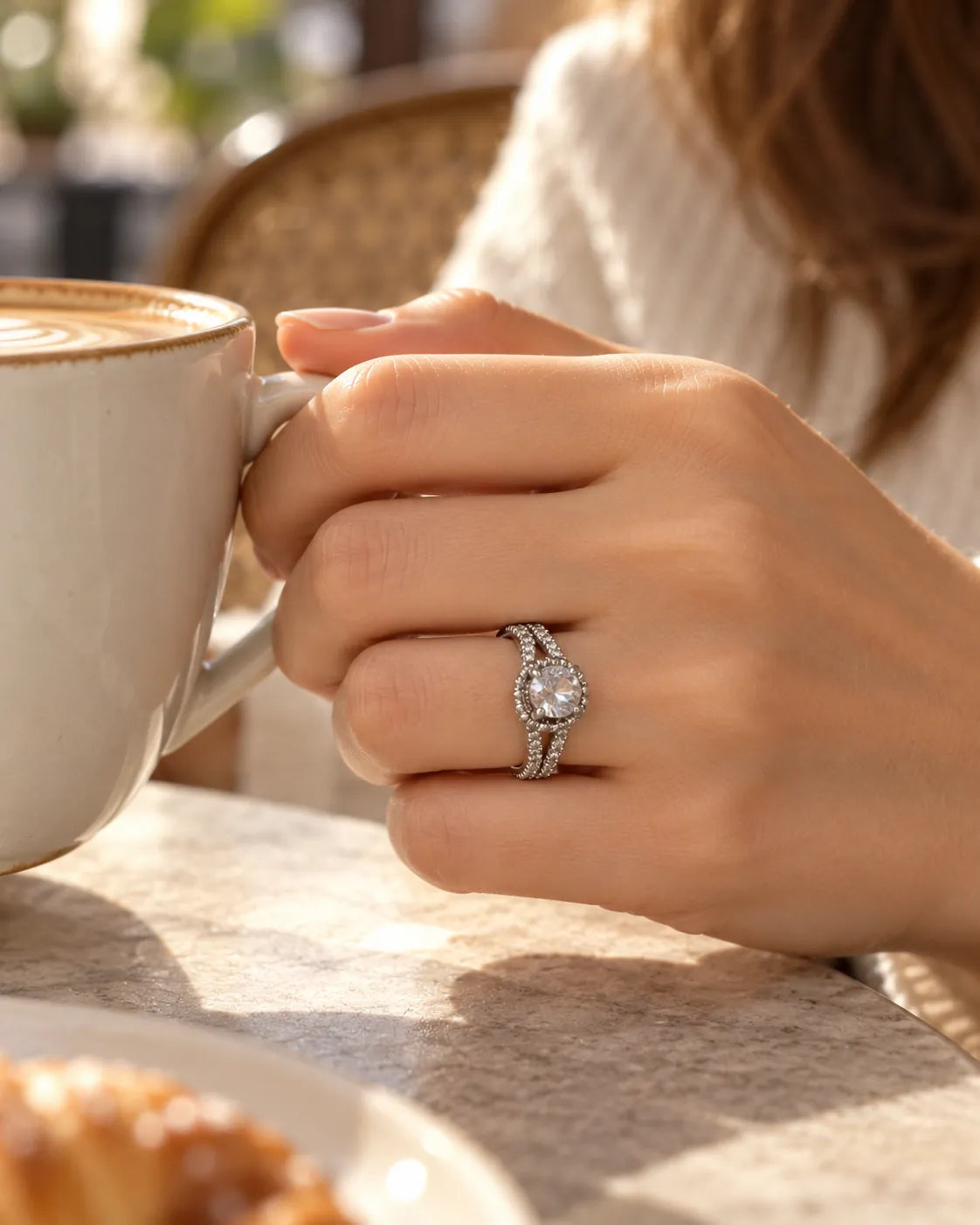 Hand holding a coffee cup wearing the silver solitaire ring