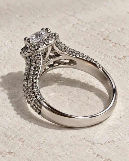 Silver split-shank halo ring on a textured cream surface