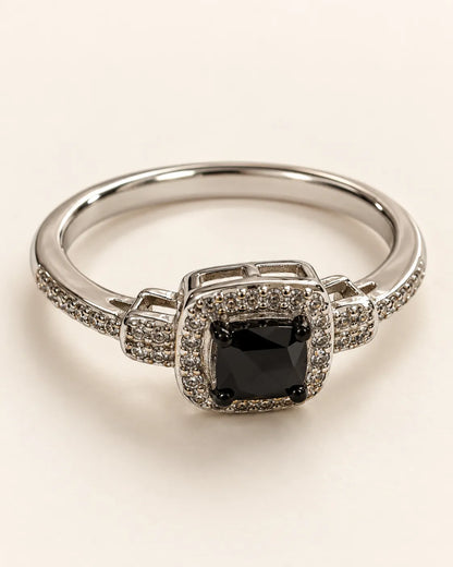 Silver halo ring with square black cubic zirconia centre on a cream background