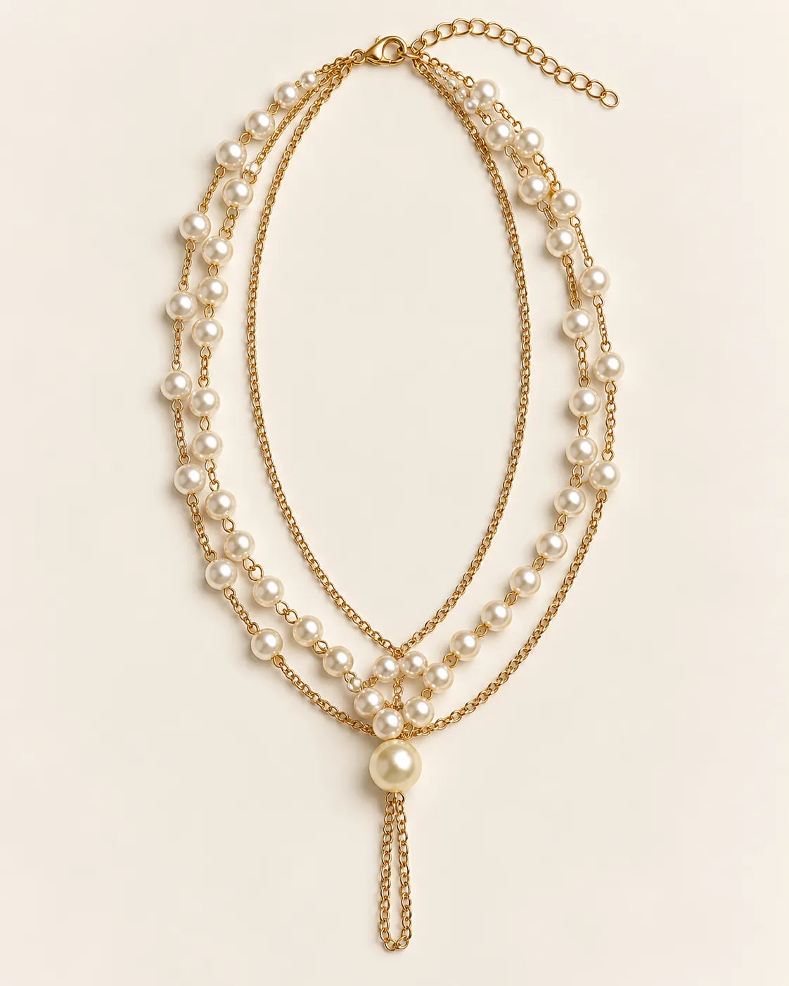 Gold Élan three-layer pearl-style necklace with Y-drop on cream