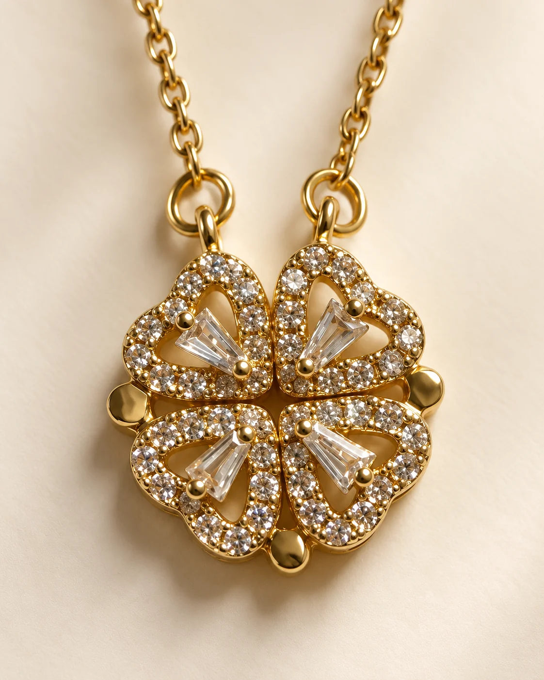 Close-up of the Amora four-heart clover pendant showing pavé and baguette-cut stones