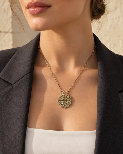 Model in a black blazer wearing the dainty Amora gold four-heart clover necklace