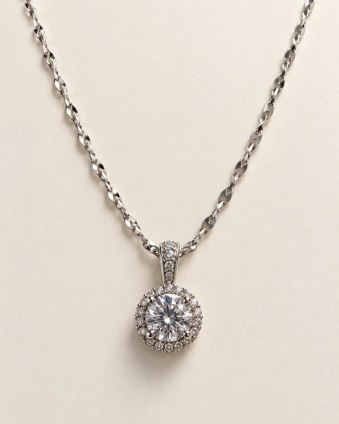 Luna silver round halo pendant with a clear centre stone on a cream background
