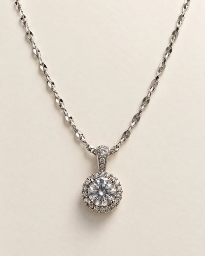 Luna silver round halo pendant with a clear centre stone on a cream background