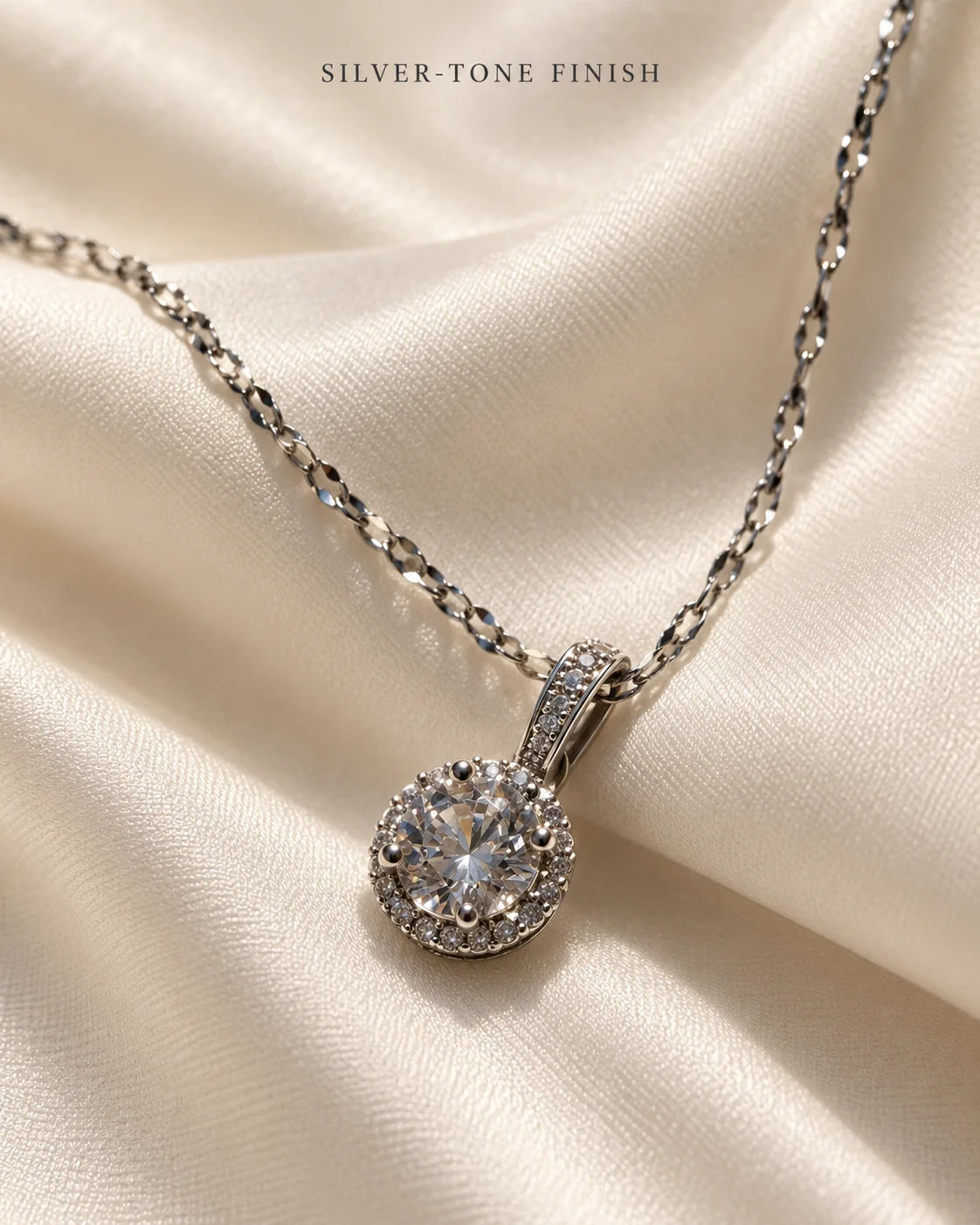 Silver-tone finish: Luna round halo pendant on ivory satin