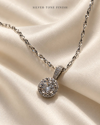 Silver-tone finish: Luna round halo pendant on ivory satin