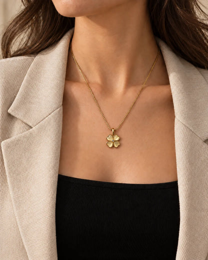 Model in a beige blazer wearing the dainty Primrose clover necklace