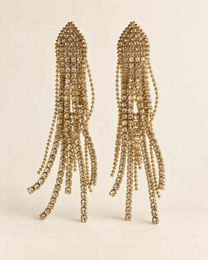 Long white rhinestone tassel drop earrings on a cream background