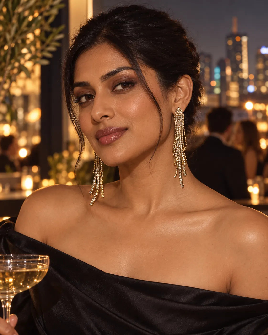 Model in a black off-shoulder top wearing the rhinestone tassel earrings at night