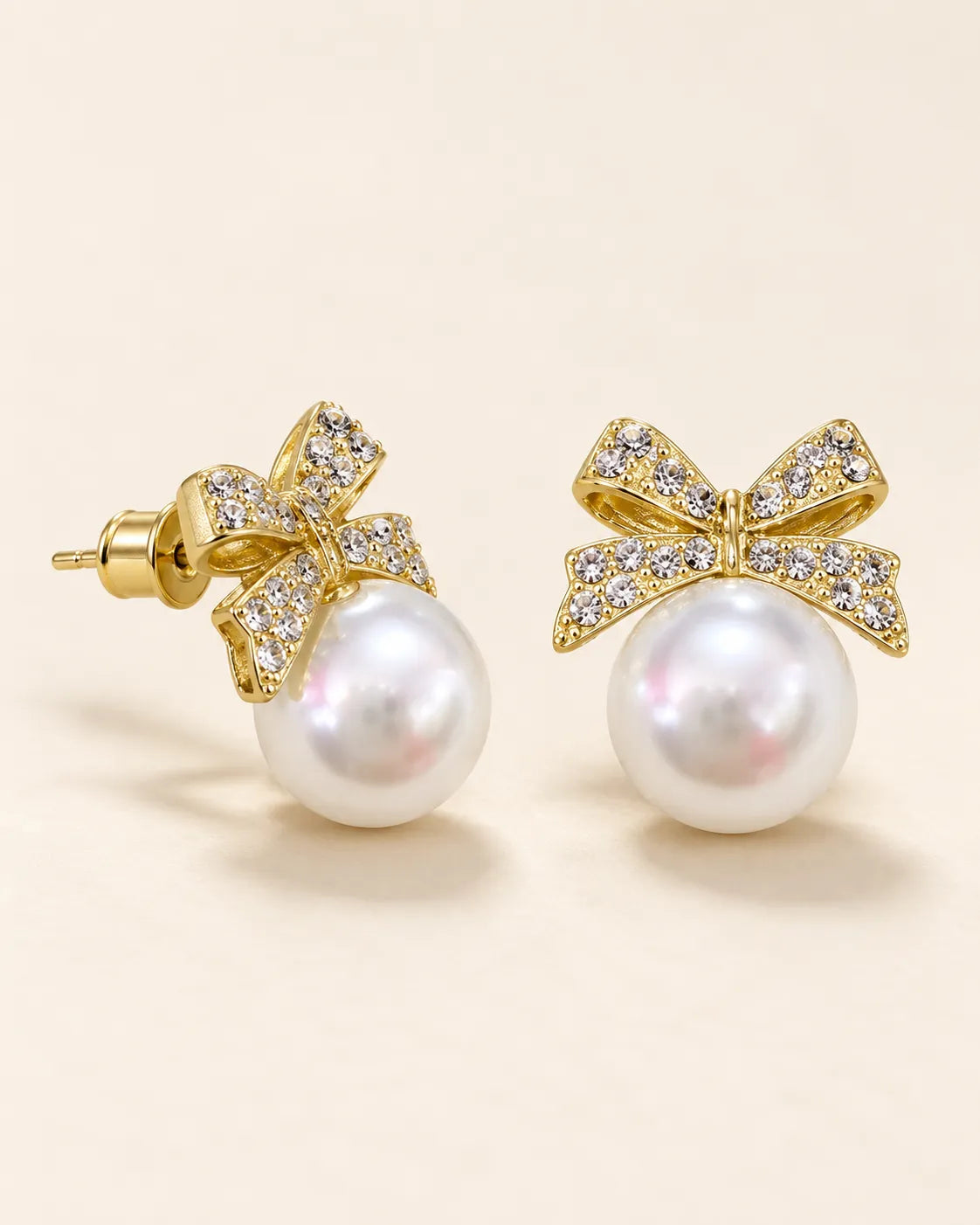 Angled view of the gold bow and pearl-look studs showing the posts