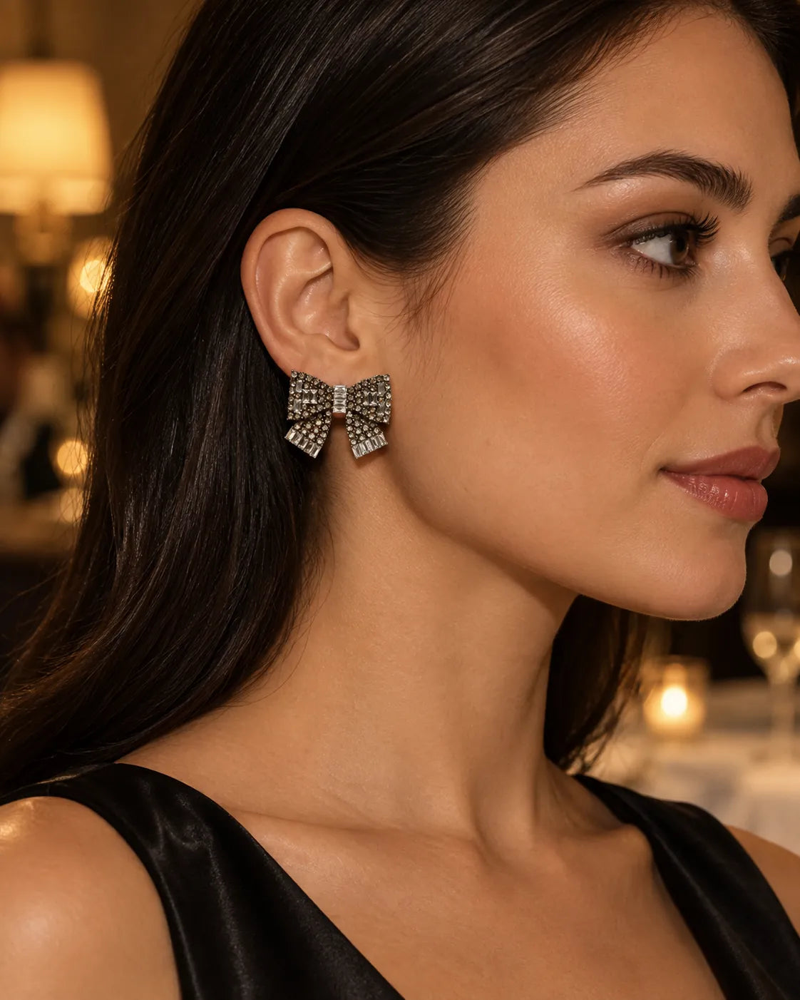 Close-up profile of a model wearing the clear rhinestone bow stud earring