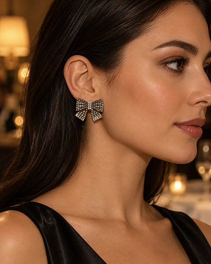 Close-up profile of a model wearing the clear rhinestone bow stud earring