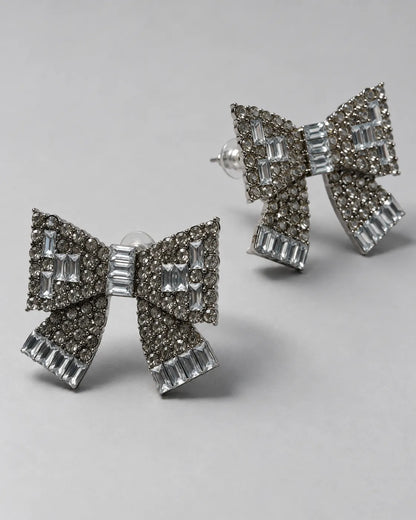 Angled view of the baguette and round rhinestone bow studs on grey