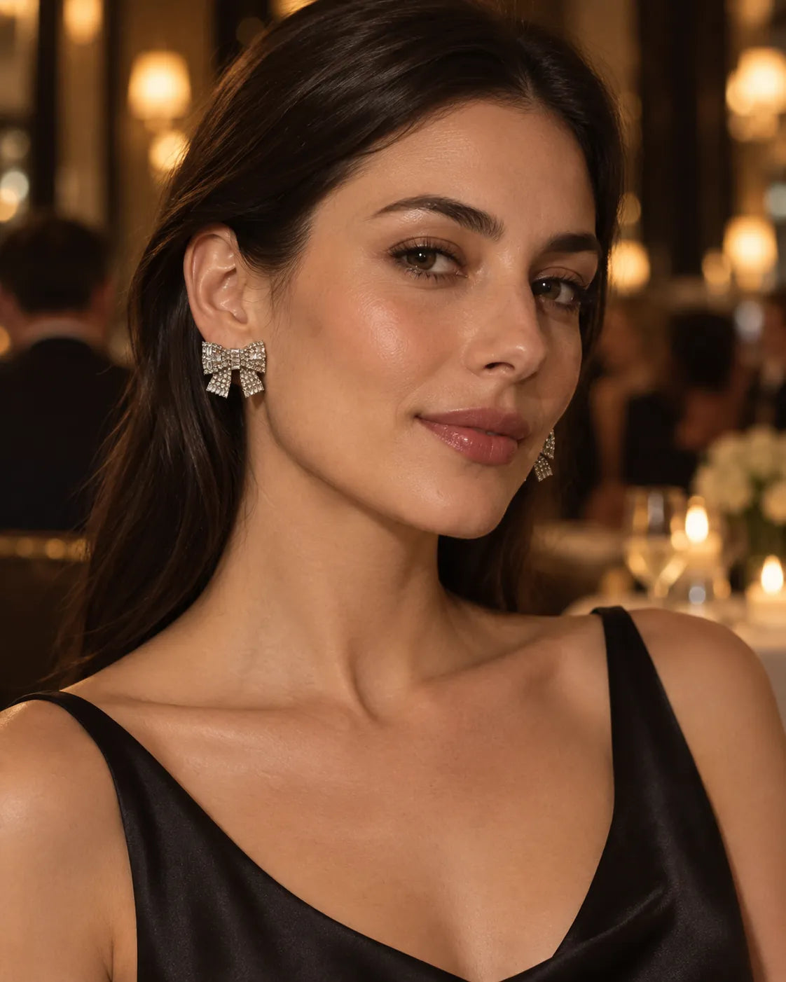 Model in a black dress at an evening event wearing the rhinestone bow studs