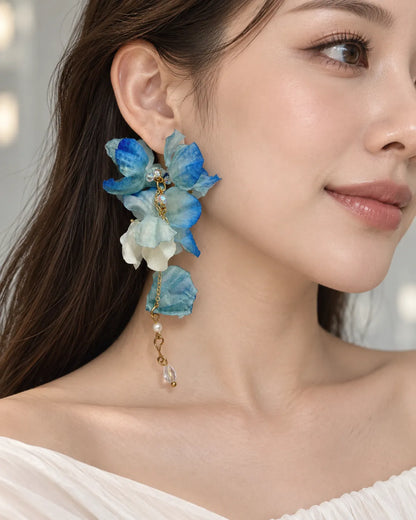 Model in a white top wearing the blue fabric flower earrings