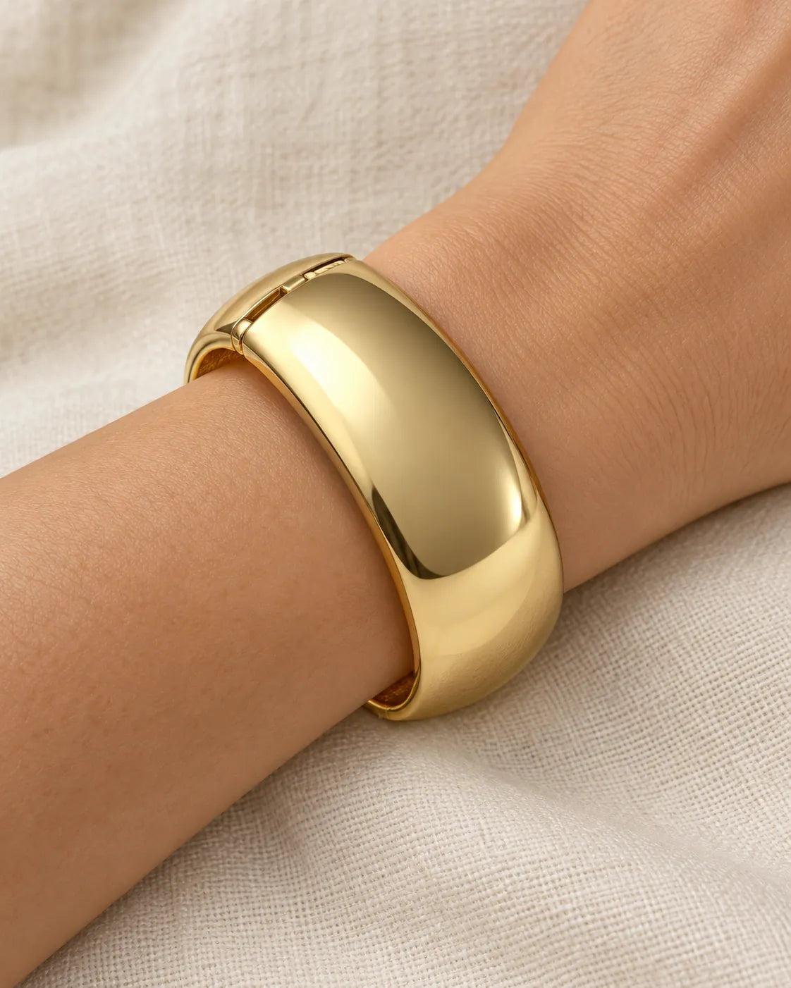 Close-up of the wide gold cuff on the wrist